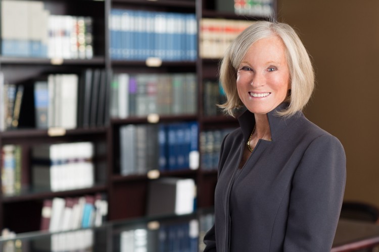 headshot of a female law partner with law books in the background