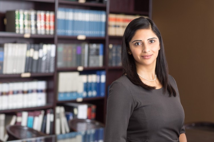 headshot of a female lawyer with law books in the background
